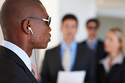 Buy stock photo Shot of a serious bodyguard protecting his client who is giving a presentation
