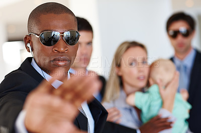 Buy stock photo Shot of a bodyguard shielding his clients at a public event