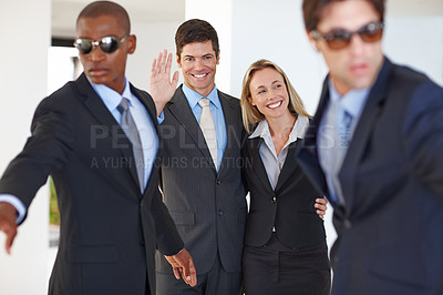 Buy stock photo Shot of a politician and his family waving at a public event with bodyguards protecting them