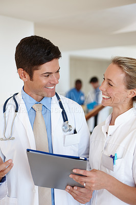 Buy stock photo Shot of a male doctor and a female nurse discussing medical records