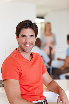 Buy stock photo Casual, businessman and smile in portrait at office with colleagues, working or job or happy. Male person, company and confidence with coworkers at desk for events management, planner or coordinator