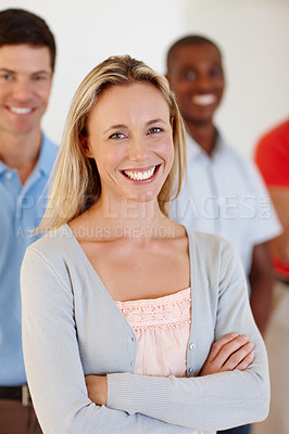 Buy stock photo Portrait of an attractive businesswoman in casualwear with her colleagues standing behind her