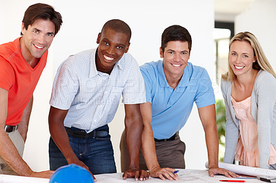 Buy stock photo Portrait of a team of architects standing with blueprints in front of them