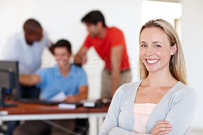 Buy stock photo Portrait of an attractive female designer with her colleagues working in the background
