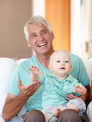 Buy stock photo Grandfather, toddler and happy in house for growth, development and childcare on sofa or couch. Mature man, baby and home with cheerful, smile and playing in living room for motor skills or learning
