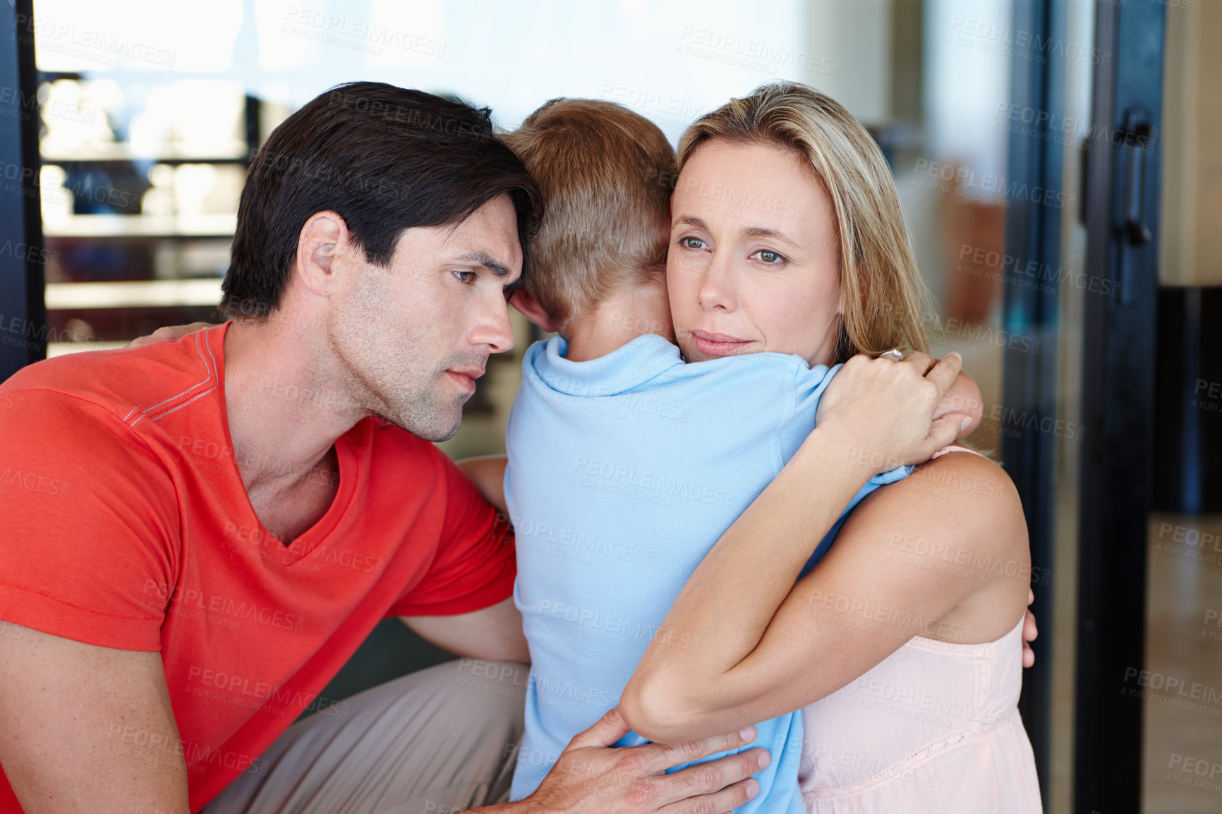 Buy stock photo Shot of a loving mother and father tenderly embracing their young son