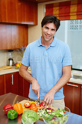 Buy stock photo Man, cooking and salad in kitchen in portrait for wellness with diet in healthy eating on counter for nutrition. Home, chef and green with dinner with vegetables for wellbeing in confidence or pride