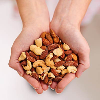 Buy stock photo Cropped shot of a bunch of mixed nuts in a person's cupped hands