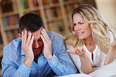 Buy stock photo Shot of a young couple having a disagreement while sitting at home
