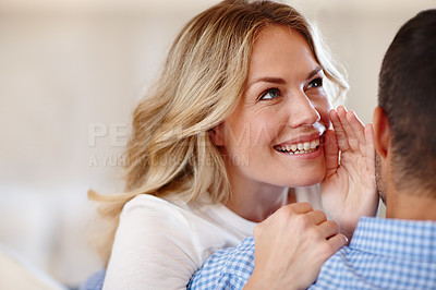 Buy stock photo Rearview shot of a woman whispering into her husband's 