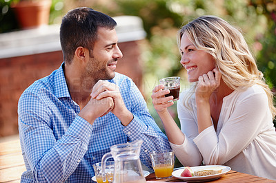 Buy stock photo Shot of a young couple enjoying breakfast outdoors