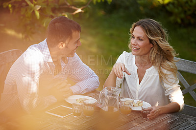 Buy stock photo Couple, outdoors or dinner with tablet and smile at sunset, conversation for relationship or marriage. Female, male person or outside at table for meal with technology, healthy communication or juice