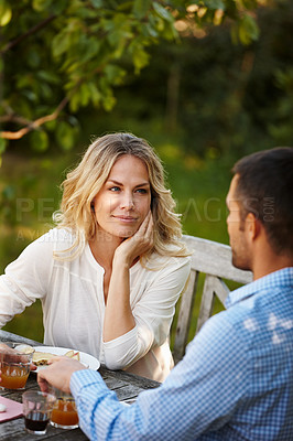 Buy stock photo Shot of a happy young couple enjoying dinner outside