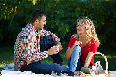 Buy stock photo Happy man, woman and picnic in park with basket for food, snacks and drink in outdoor. Couple and smiling in enjoying on date with touching, romance and love in summer for bonding or talking