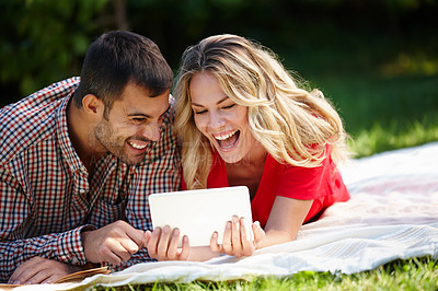 Buy stock photo Couple, blanket and tablet to relax on grass, internet and commitment to relationship in outdoor nature. Happy people, bonding and streaming for marriage, romance and online on vacation or holiday