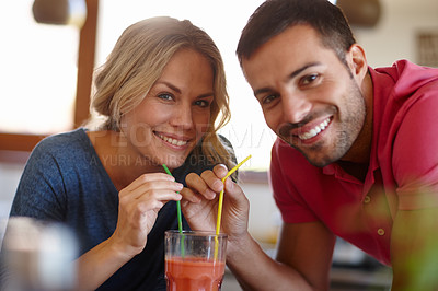 Buy stock photo Shot of a happy young couple sharing a milkshake