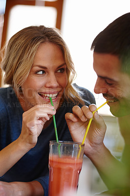Buy stock photo Happy couple, juice and sharing in house with drink, smile and color straw for relax together. Love, milkshake and happiness of man with woman in home for romantic relationship, date and glass