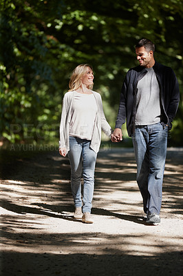 Buy stock photo Couple, holding hands and walk in park with love on date for relationship and bonding with smile. People, walking and outdoor with happiness in nature with partnership, conversation and happy couple.