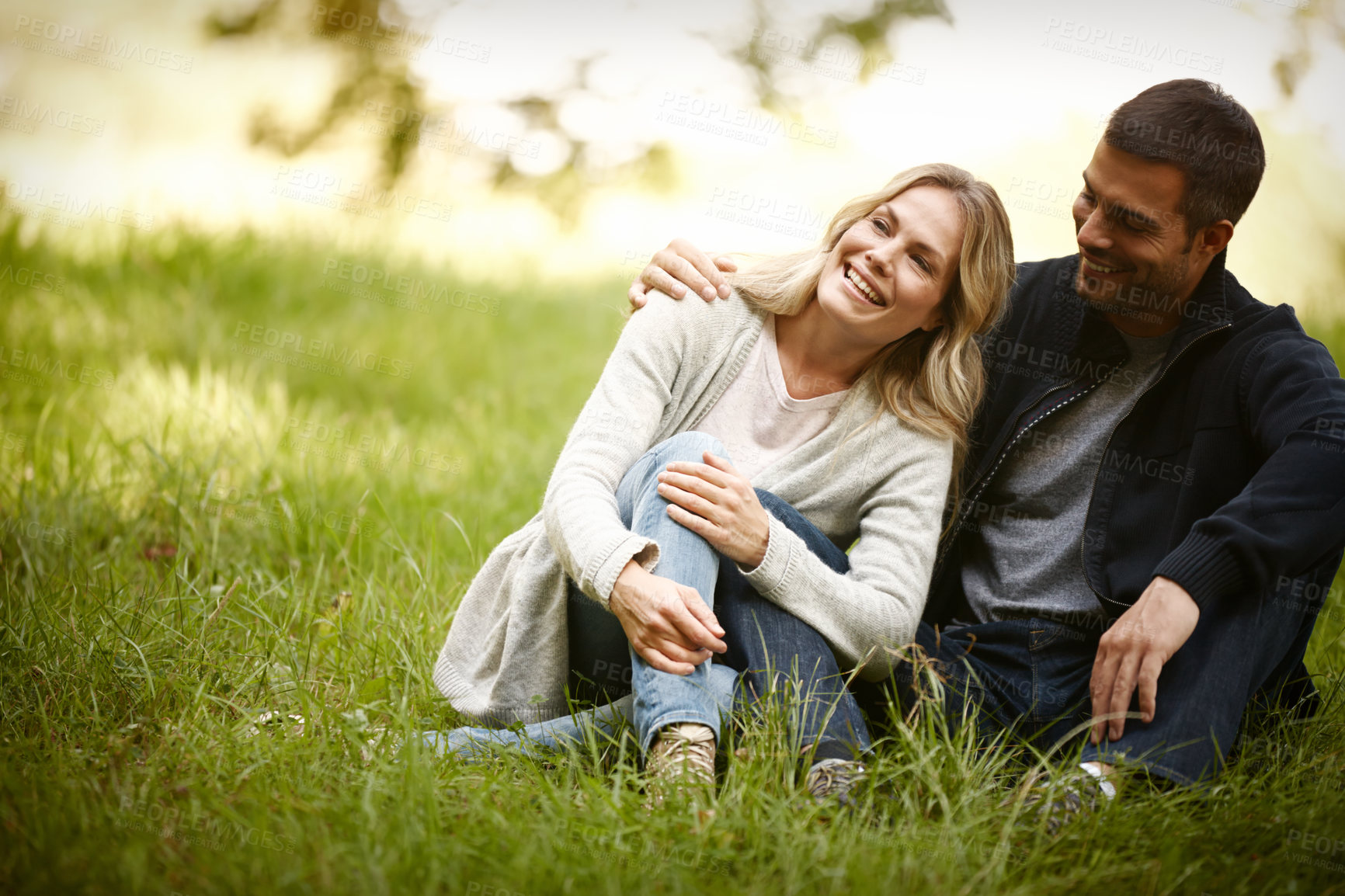 Buy stock photo Couple, embrace and relax outdoors on grass, together and love in relationship or bonding in park. Happy people, support and hug on holiday or vacation in nature, laughing and commitment on date