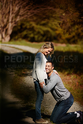 Buy stock photo Couple, hug and stomach in park for love, knees and commitment to relationship in outdoor nature. Happy people, bonding and embrace in marriage, celebrate and pregnancy on vacation or holiday date