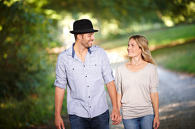 Buy stock photo Couple, hand holding and happy with walk in park for love, bonding with care and support in healthy relationship. Man, woman and outdoor for date with romance, trust and commitment for marriage