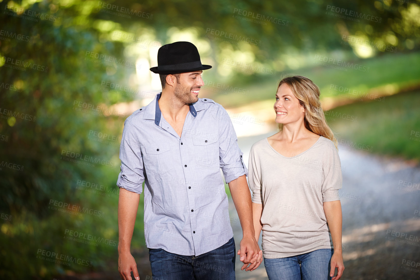 Buy stock photo Couple, hand holding and happy with walk in park for love, bonding with care and support in healthy relationship. Man, woman and outdoor for date with romance, trust and commitment for marriage