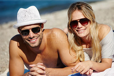 Buy stock photo Couple, sunglasses and relax on beach towel, smile and peace on vacation or lying by water. People, happy and tropical ocean for bonding on weekend, outdoor nature and love for marriage or romance