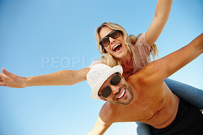 Buy stock photo Couple, sunglasses and piggyback on vacation, holiday and peace or flying game by blue sky. People, below and mockup space for bonding on weekend, outdoor nature and love for marriage or romance