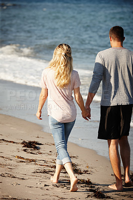 Buy stock photo Couple, walking and holding hands on shore of beach, peace and travel to nature for holiday. People, back and calm stroll on weekend or vacation, love and date for relationship or marriage and ocean