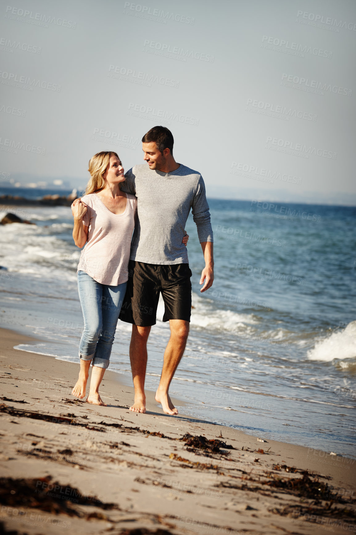 Buy stock photo Couple, walking and hug on sand of beach, peace and travel to nature for holiday. People, embrace and calm on weekend trip or vacation, love and date for relationship or marriage and ocean waves