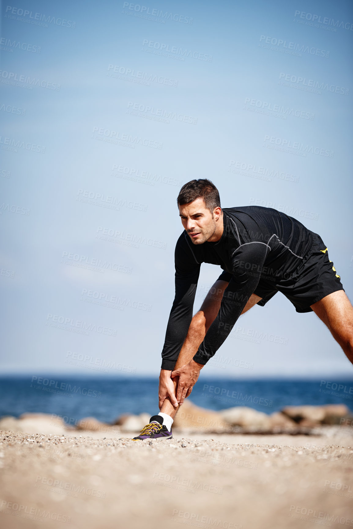 Buy stock photo Man, stretching and beach on sand with balance for health, fitness and exercise by ocean for peace or calm. Athlete, workout and outdoor by sea in morning for wellness, start and training by nature