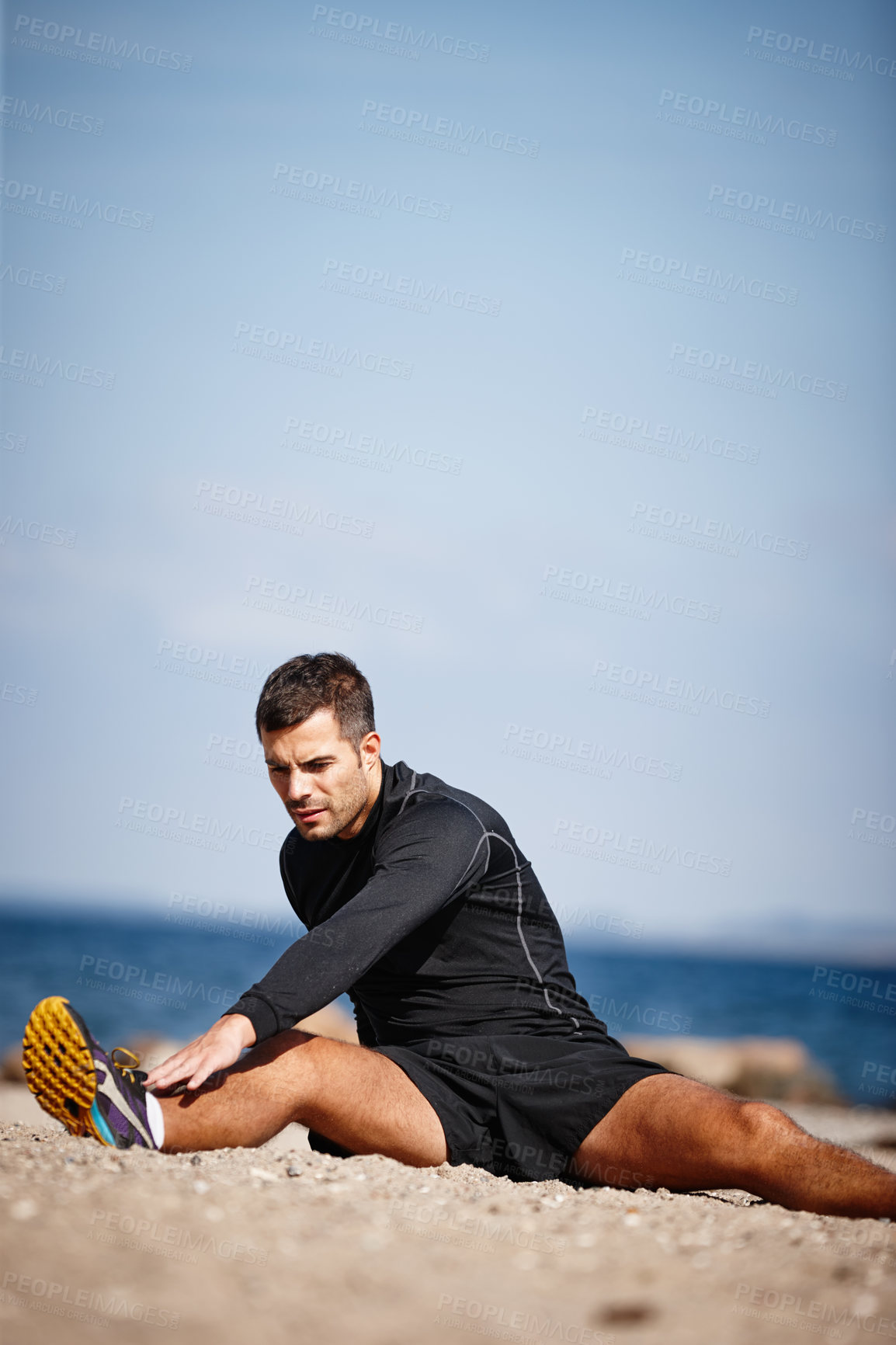 Buy stock photo Man, stretching and wellness at beach for exercise with fitness motivation, sand and blue sky. Male person, training and nature by ocean with workout for sports, strong body and health activity