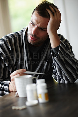 Buy stock photo Man, sad and sick with headache, thermometer for fever with sinus or virus at home. Health fail, medication or pills for flu or cold, monitor condition for allergies and viral infection with medicine