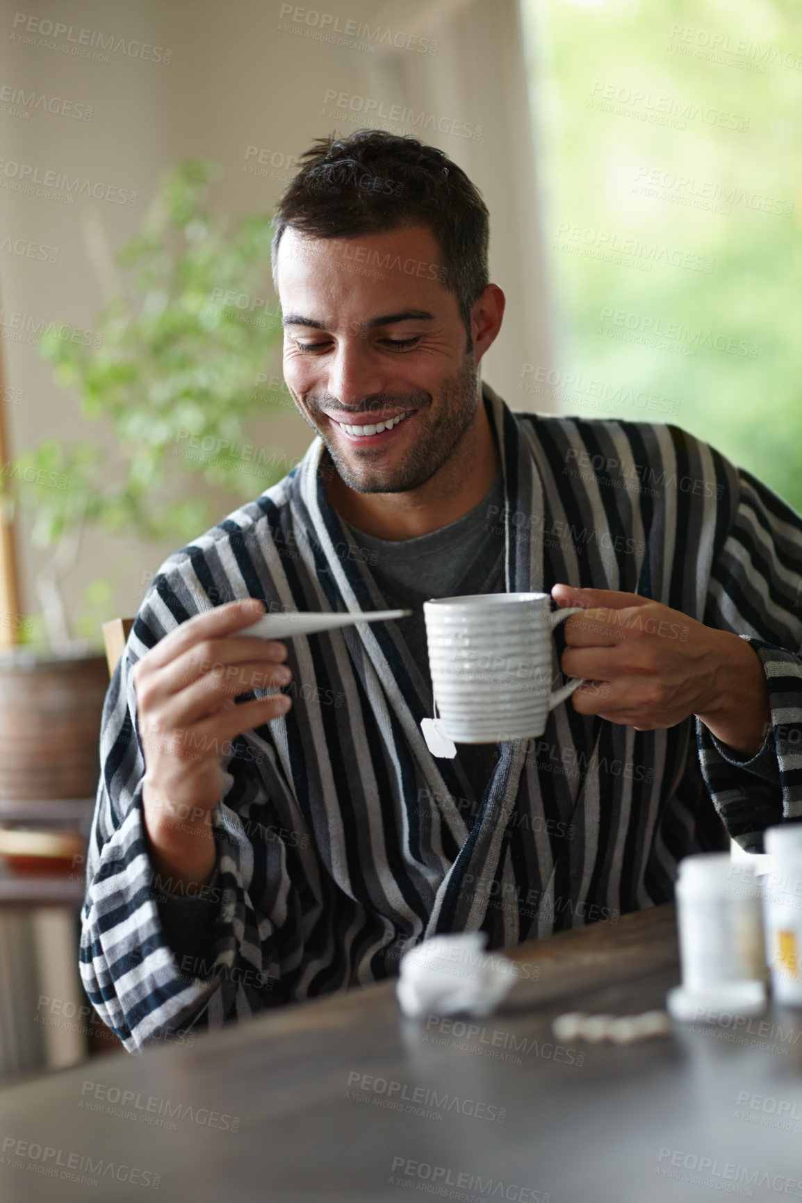 Buy stock photo Man, reading and temperature on thermometer at home holding mug with herbal tea for recovery. Happy, male and medicine for illness, disease and virus smiling for good news on positive health results 