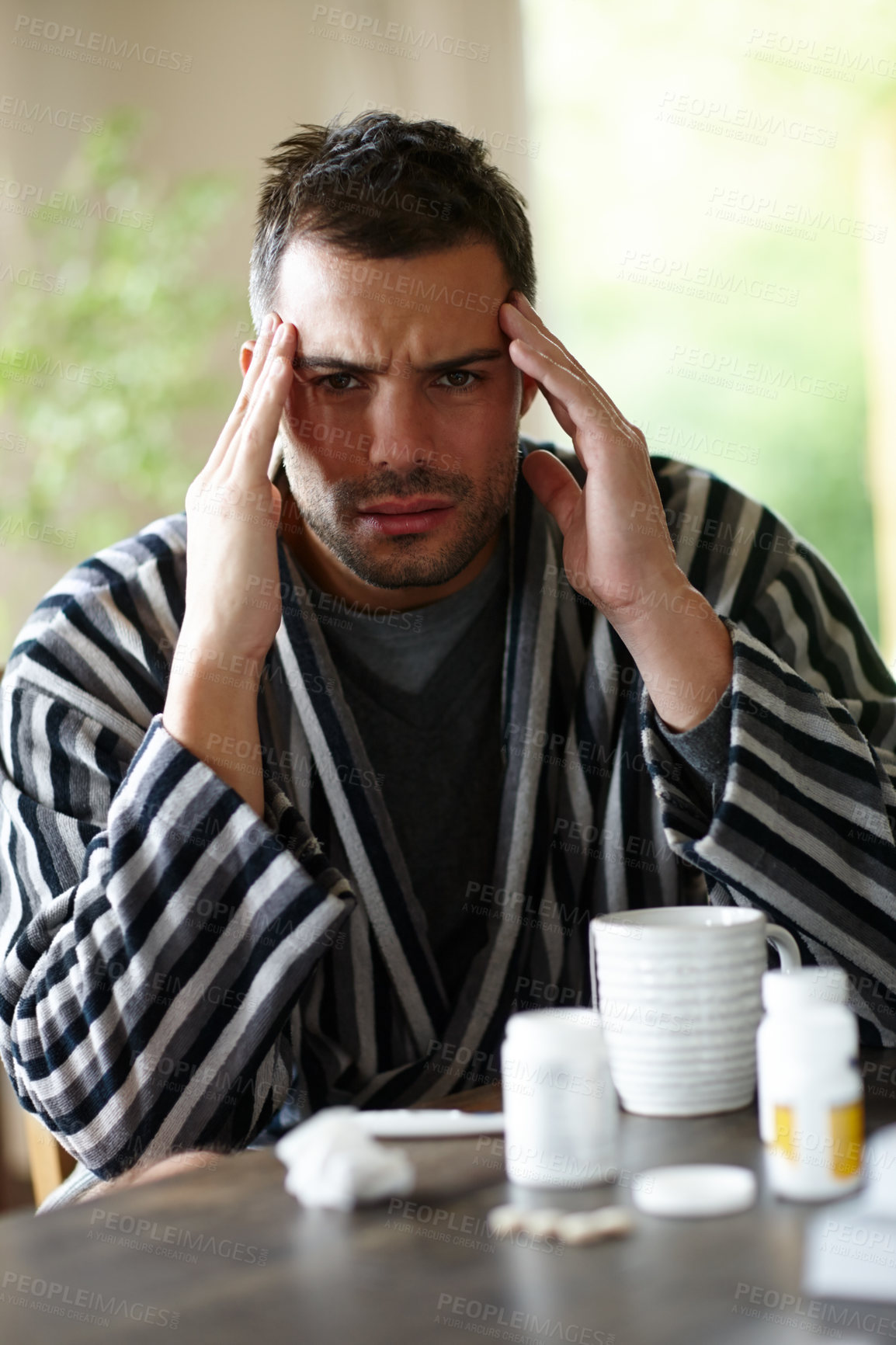 Buy stock photo Sick, man and headache with medication in house rubbing temples with herbal tea for recovery. Unhealthy, male person and vitamins for illness, disease and virus and antibiotics for treatment