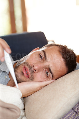 Buy stock photo Man on sofa, sick and thermometer for fever, healthcare and wellness with virus, viral infection or bacteria at home. Burnout, fatigue and health fail, monitor condition for illness with cold or flu
