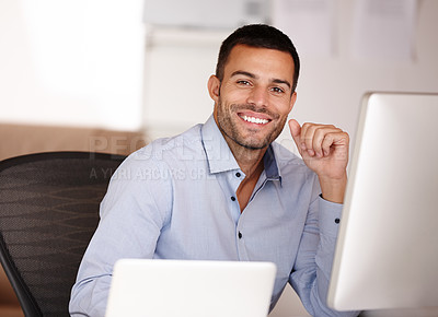Buy stock photo Portrait of a smiling young man sitting behind a computer screen
