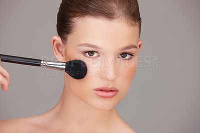 Buy stock photo Woman, portrait and makeup brush in studio for beauty, foundation or facial routine with gray background. Skincare, serious and female model for glow, powder cosmetic application or self care tool