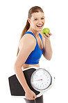 A pretty teenager holding an apple in her hand while carrying a scale