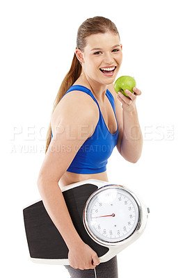 Buy stock photo A pretty teenager holding an apple in her hand while carrying a scale
