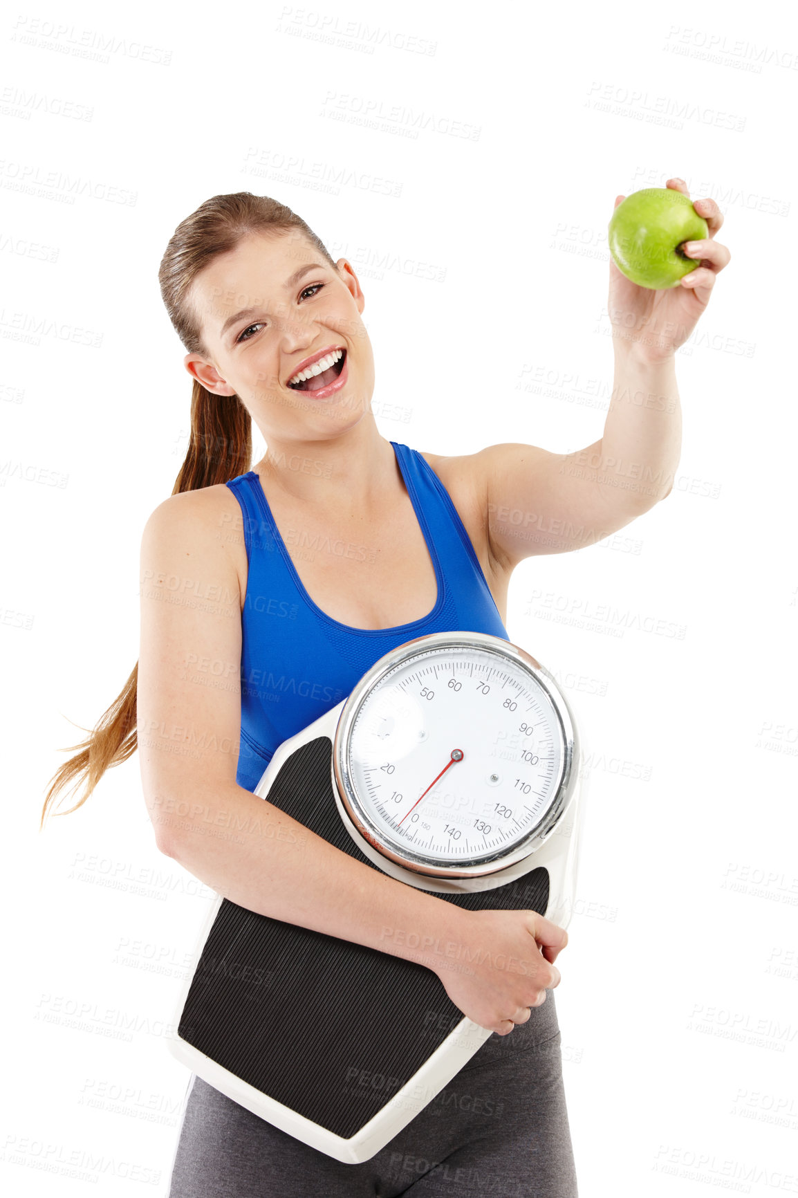 Buy stock photo A pretty teenager holding an apple in her hand while carrying a scale