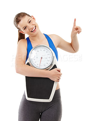 Buy stock photo A pretty teenager carrying a scale and pointing up at copyspace