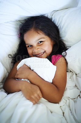 Buy stock photo Shot of a smiling little girl hugging the duvet in bed