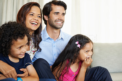 Buy stock photo A happy young family enjoying some time spent sitting together