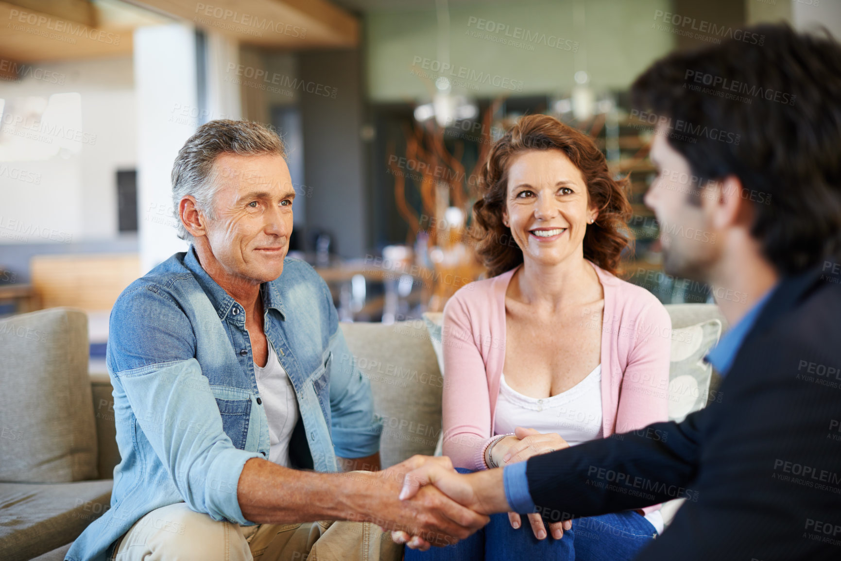 Buy stock photo Mature couple, broker and handshake in house for mortgage for retirement in planning, finances and advice. Man, woman and consultant for pension, deal or agreement in lounge with advisor in thank you