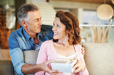 Buy stock photo A mature man presenting his wife with a surprise gift