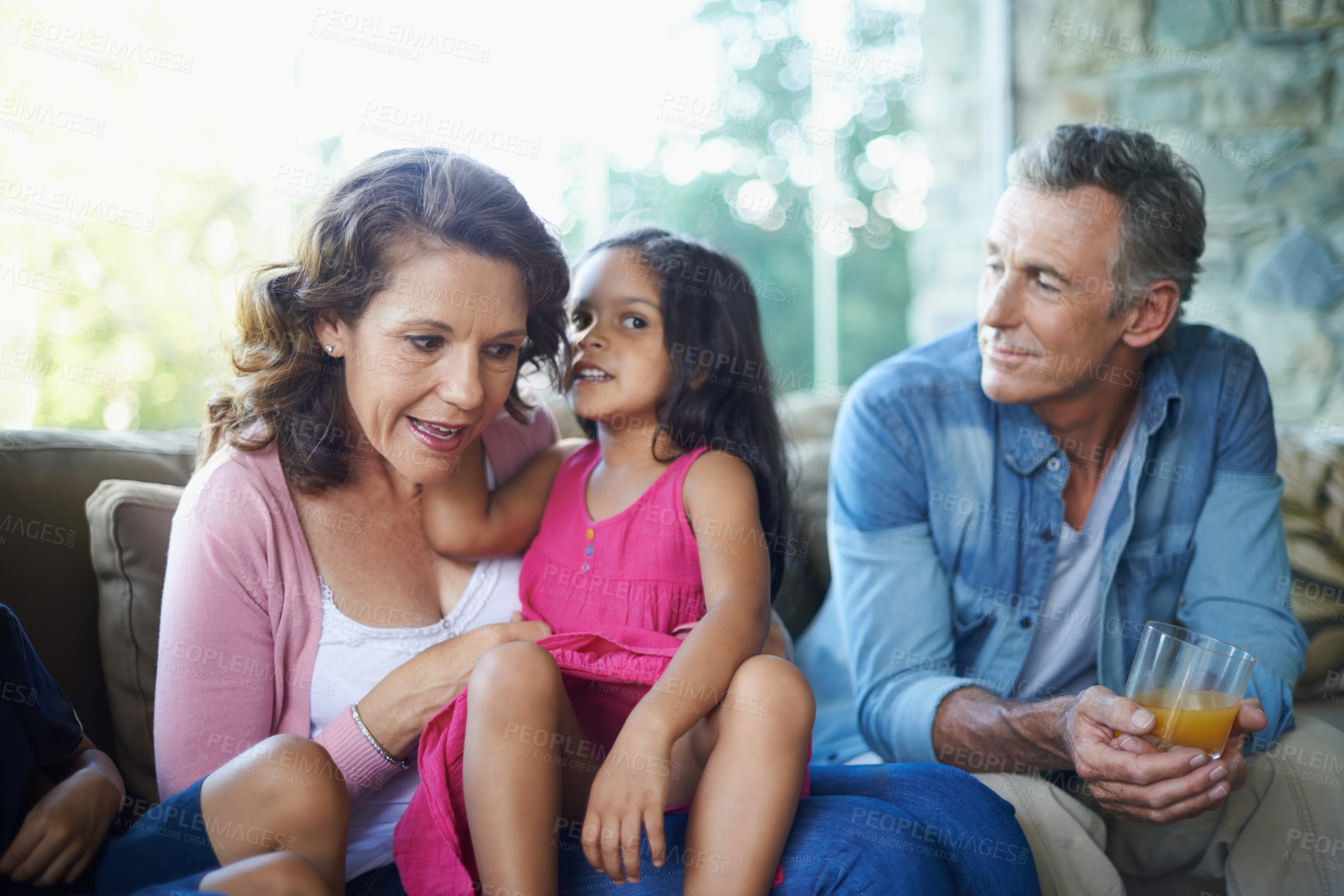 Buy stock photo Whisper, bonding and happy family on sofa for conversation, secret or gossip talking. Smile, house and grandmother, grandfather and child on couch for comfort, care and joke together in home lounge