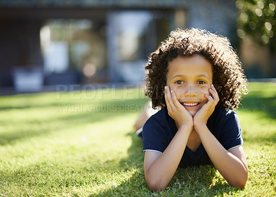 Buy stock photo A cute little boy lying on the grass with his head in his hands