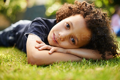 Buy stock photo Portrait, boy child and lying on grass in outdoor park for freedom, comfort and relax in nature. Happiness, holiday and young kid on lawn for childhood, weekend break or family trip in Monaco