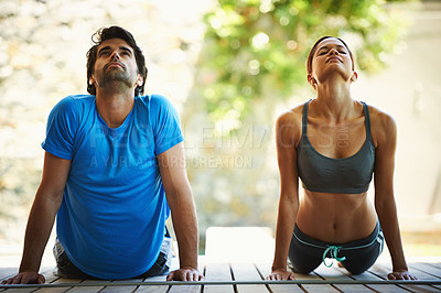 Buy stock photo Two young adults stretching together during a yoga session